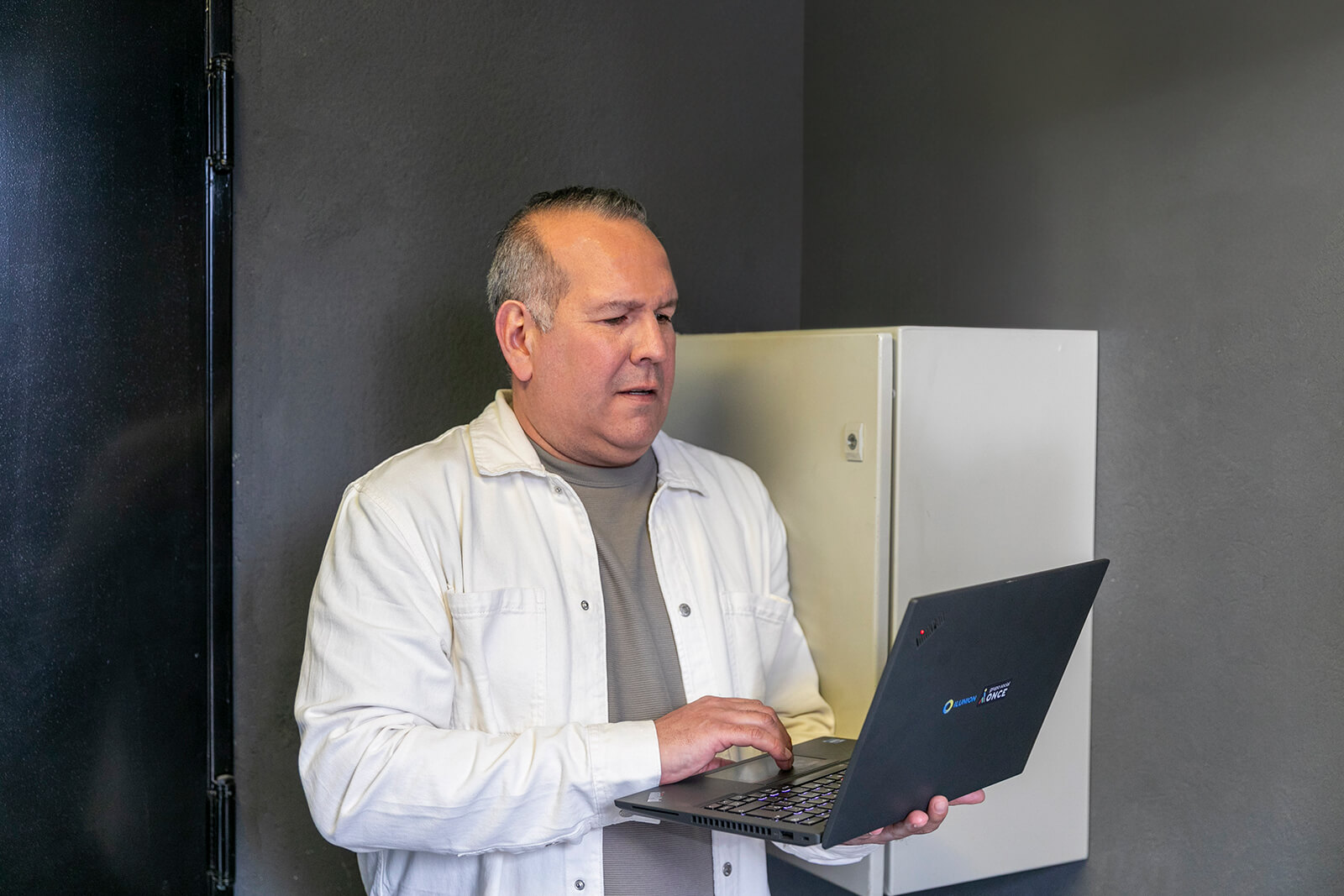 Antonio Suárez trabajando con un ordenador al lado de los servidores.